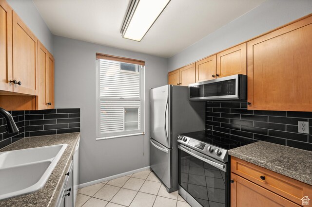 229 N B St Unit 4, Salt Lake City, UT 84103 - kitchen featuring dark countertops, a sink, stainless steel appliances, baseboards, and tasteful backsplash