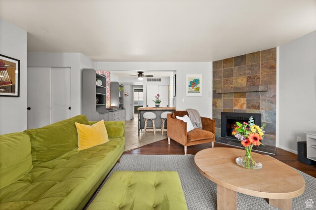 229 N B St Unit 4, Salt Lake City, UT 84103 - living area with a tiled fireplace, a ceiling fan, wood finished floors, and visible vents