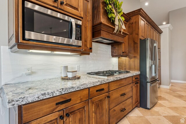10921 S Renengade View Ln W, South Jordan, UT 84095 - kitchen featuring light stone counters, decorative backsplash, baseboards, and stainless steel appliances