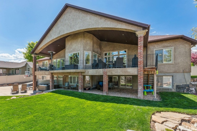 10921 S Renengade View Ln W, South Jordan, UT 84095 - back of house with a hot tub, a balcony, a yard, a patio, and stucco siding