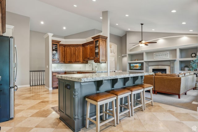 10921 S Renengade View Ln W, South Jordan, UT 84095 - kitchen featuring ceiling fan, vaulted ceiling, light stone counters, freestanding refrigerator, and open floor plan