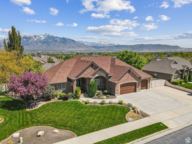 10921 S Renengade View Ln W, South Jordan, UT 84095 - view of front of property with an attached garage, a front lawn, brick siding, a mountain view, and driveway