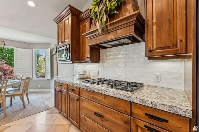 10921 S Renengade View Ln W, South Jordan, UT 84095 - kitchen with light stone countertops, stainless steel appliances, baseboards, backsplash, and custom exhaust hood