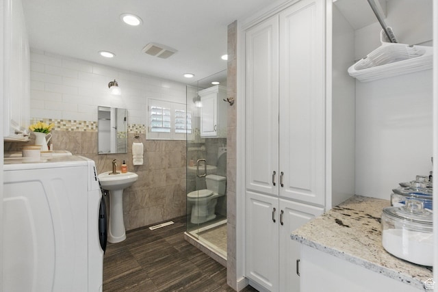 15 S 300 E, Payson, UT 84651 - bathroom featuring washer / clothes dryer, visible vents, tile walls, a stall shower, and a sink