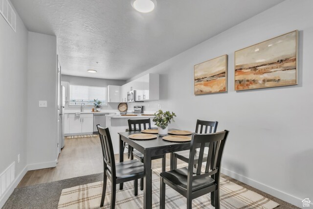 1140 W 950 N Unit E202, Orem, UT 84057 - dining room featuring a textured ceiling, baseboards, and visible vents