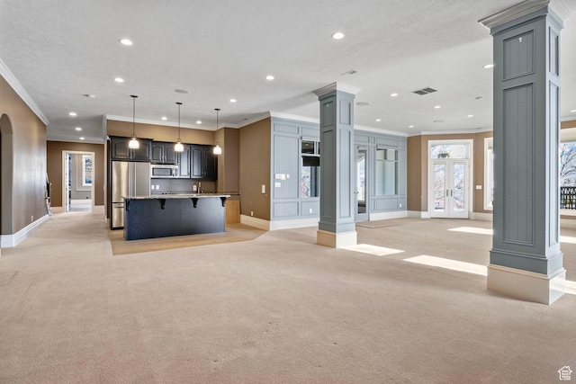 unfurnished living room featuring light colored carpet, recessed lighting, ornate columns, and crown molding