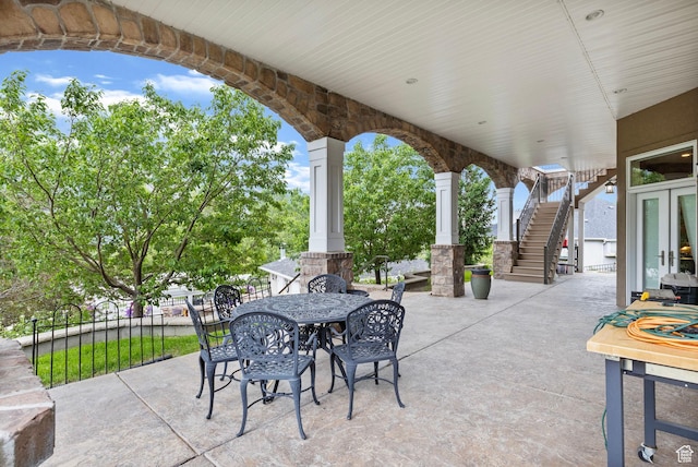 view of patio featuring outdoor dining space and stairway