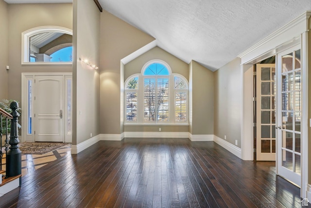 foyer entrance with wood-type flooring, french doors, and lofted ceiling