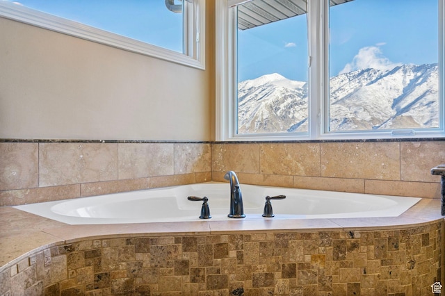 bathroom with a garden tub and a mountain view