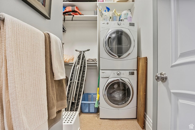 laundry room with stacked washer and clothes dryer, carpet flooring, and laundry area