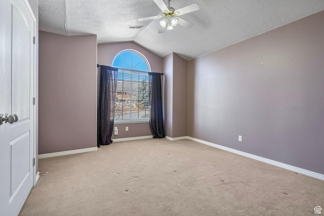 unfurnished bedroom featuring visible vents, lofted ceiling, baseboards, a textured ceiling, and carpet