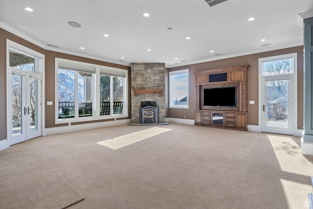 unfurnished living room with crown molding, light colored carpet, and a wealth of natural light
