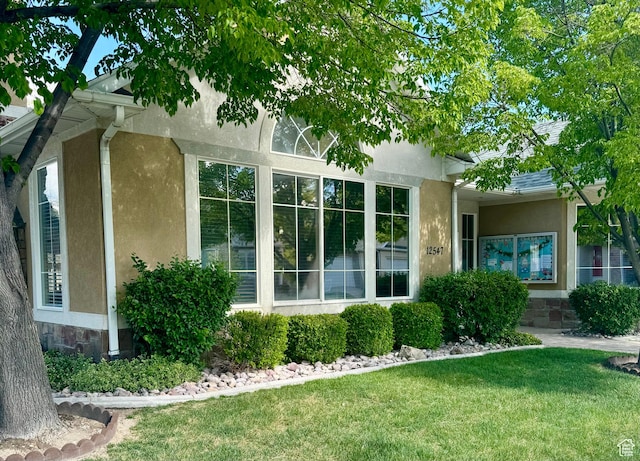 1139 Grainery Cv, Riverton, UT 84065 - view of side of home with stucco siding, a yard, and stone siding