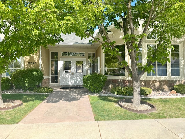 1139 Grainery Cv, Riverton, UT 84065 - view of exterior entry with a lawn and stone siding