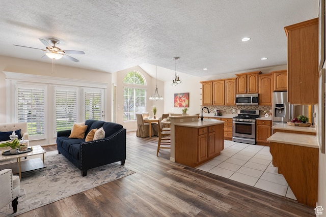 1139 Grainery Cv, Riverton, UT 84065 - kitchen featuring a ceiling fan, appliances with stainless steel finishes, light countertops, open floor plan, and a wealth of natural light