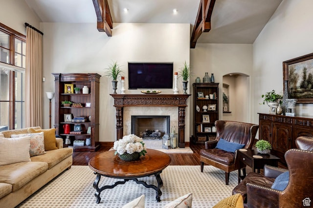 8777 S Falcon Heights Ln E, Cottonwood Heights, UT 84093 - living room with arched walkways, beam ceiling, wood finished floors, and a high end fireplace