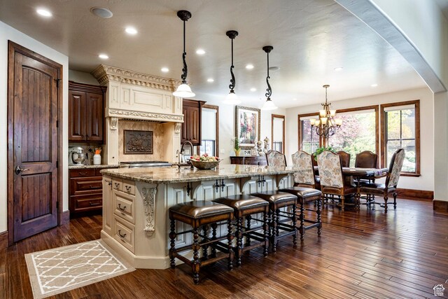 8777 S Falcon Heights Ln E, Cottonwood Heights, UT 84093 - kitchen featuring arched walkways, light stone countertops, a breakfast bar area, and a large island