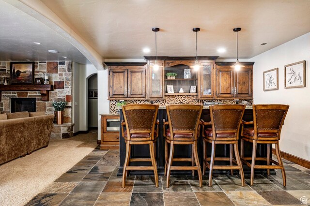 8777 S Falcon Heights Ln E, Cottonwood Heights, UT 84093 - bar with hanging light fixtures, arched walkways, baseboards, stainless steel microwave, and backsplash