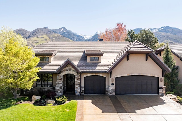 8777 S Falcon Heights Ln E, Cottonwood Heights, UT 84093 - tudor house with stucco siding, a mountain view, driveway, and stone siding