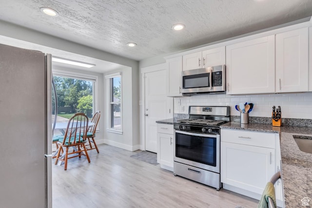 84 W Wasatch St S, Midvale, UT 84047 - kitchen with appliances with stainless steel finishes, decorative backsplash, and dark stone countertops