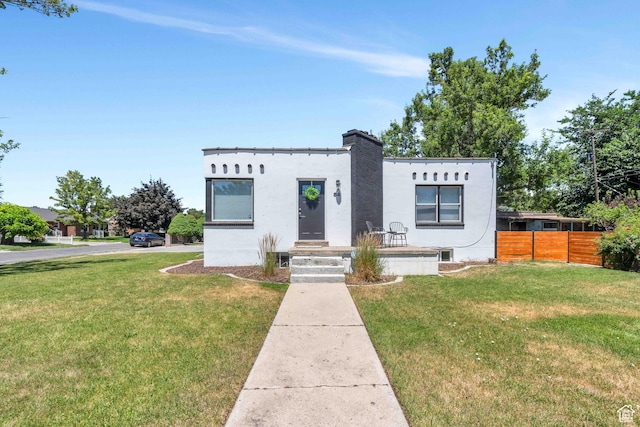 84 W Wasatch St S, Midvale, UT 84047 - mediterranean / spanish-style home featuring stucco siding, a chimney, fence, and a front yard