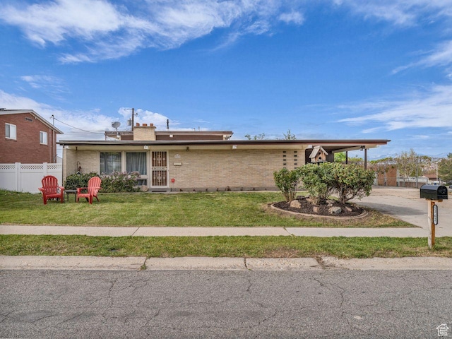 5362 W Elaine Ave, West Valley City, UT 84120 - view of front of home featuring fence, a front yard, and brick siding