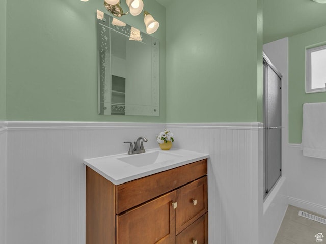 5362 W Elaine Ave, West Valley City, UT 84120 - full bathroom featuring visible vents, tile patterned flooring, wainscoting, vanity, and enclosed tub / shower combo