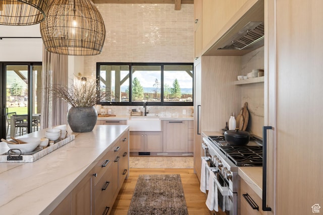 205 W Lazy Acres Ln, Kamas, UT 84036 - kitchen featuring a healthy amount of sunlight, light stone countertops, light wood-type flooring, a sink, and stainless steel range