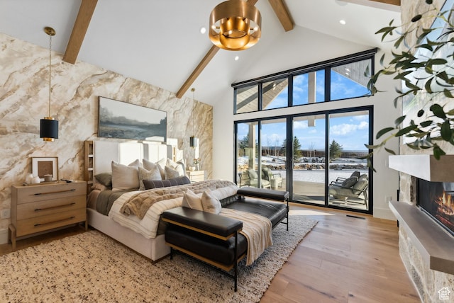 205 W Lazy Acres Ln, Kamas, UT 84036 - bedroom featuring access to exterior, wood finished floors, high vaulted ceiling, beamed ceiling, and a glass covered fireplace