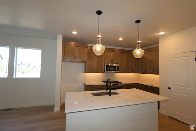 4888 W Coulter Unit 703, Highland, UT 84003 - kitchen with stainless steel microwave, backsplash, light countertops, light wood-type flooring, and pendant lighting