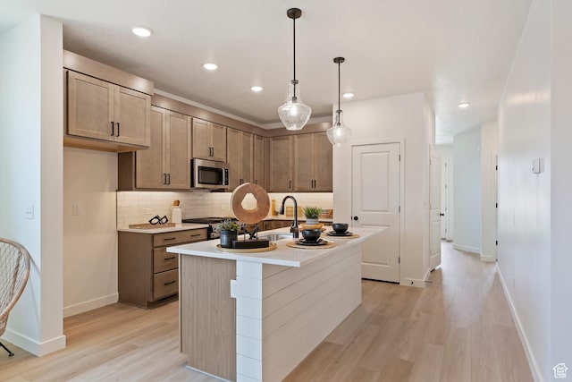 4888 W Coulter Unit 703, Highland, UT 84003 - kitchen with stainless steel microwave, light wood finished floors, tasteful backsplash, recessed lighting, and light countertops