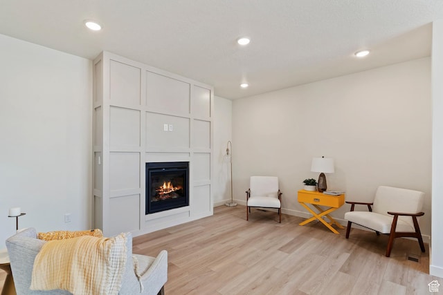 4888 W Coulter Unit 703, Highland, UT 84003 - living area featuring a glass covered fireplace, light wood-style flooring, and recessed lighting