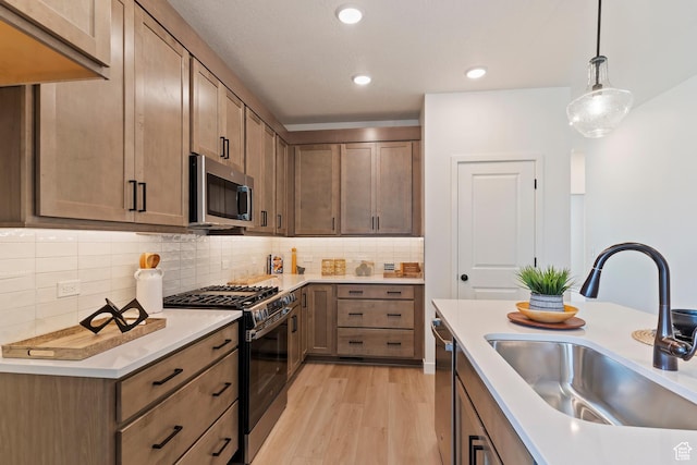 4888 W Coulter Unit 703, Highland, UT 84003 - kitchen featuring appliances with stainless steel finishes, light wood finished floors, pendant lighting, backsplash, and recessed lighting