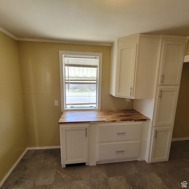 207 N Rawlins St, East Carbon, UT 84520 - kitchen featuring white cabinets, baseboards, wooden counters, and ornamental molding