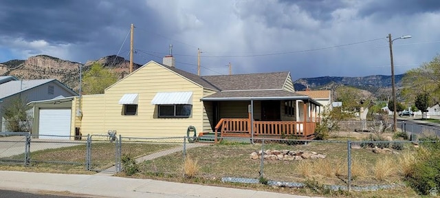 207 N Rawlins St, East Carbon, UT 84520 - bungalow-style home with a porch, a fenced front yard, a mountain view, and driveway
