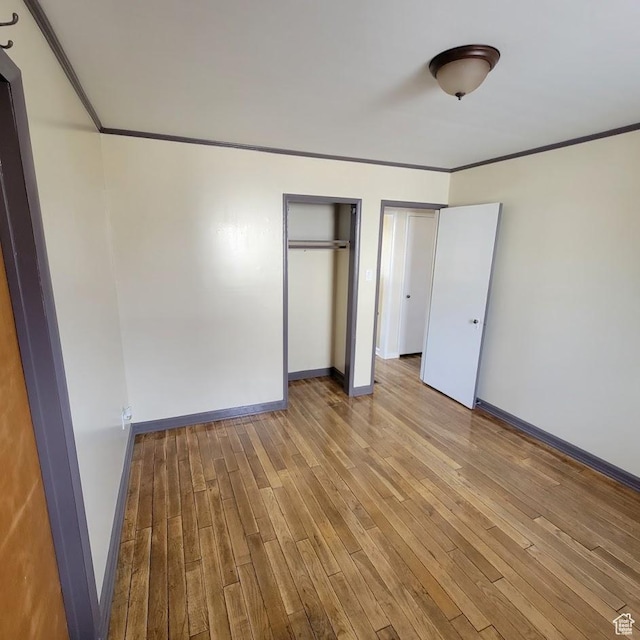 207 N Rawlins St, East Carbon, UT 84520 - unfurnished bedroom featuring crown molding, baseboards, multiple closets, and wood finished floors