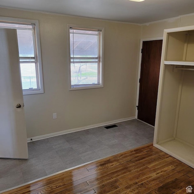 207 N Rawlins St, East Carbon, UT 84520 - unfurnished bedroom with baseboards, visible vents, ornamental molding, and wood finished floors