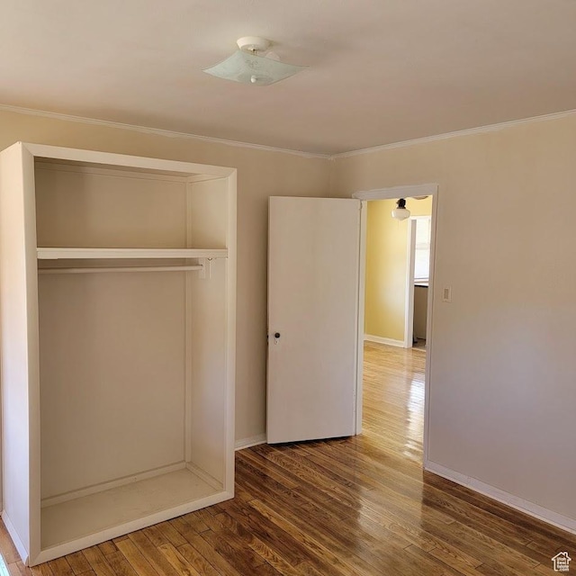 207 N Rawlins St, East Carbon, UT 84520 - unfurnished bedroom with crown molding, baseboards, wood finished floors, and a closet