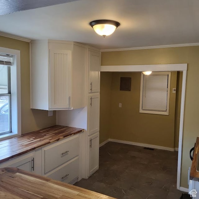 207 N Rawlins St, East Carbon, UT 84520 - kitchen featuring visible vents, baseboards, wood counters, ornamental molding, and white cabinetry