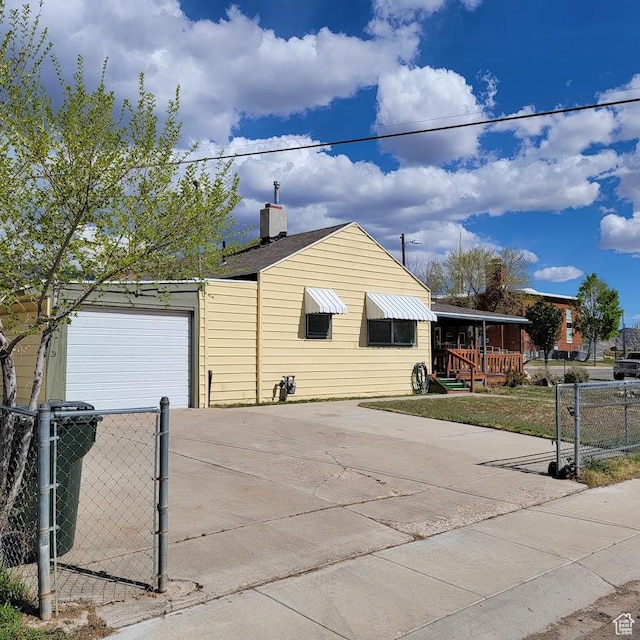 207 N Rawlins St, East Carbon, UT 84520 - exterior space with a garage, fence, driveway, and a chimney