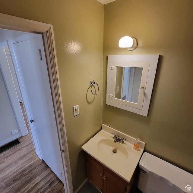 207 N Rawlins St, East Carbon, UT 84520 - bathroom with toilet, visible vents, wood finished floors, and vanity