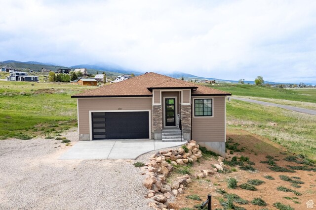 207 E Clubhouse Dr Unit 40, Garden City, UT 84028 - view of front facade featuring gravel driveway, an attached garage, and a mountain view