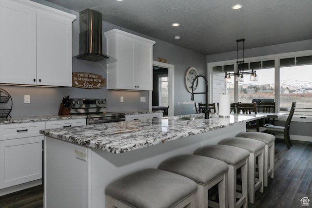 207 E Clubhouse Dr Unit 40, Garden City, UT 84028 - kitchen with stainless steel electric stove, wall chimney range hood, light stone countertops, white cabinetry, and recessed lighting
