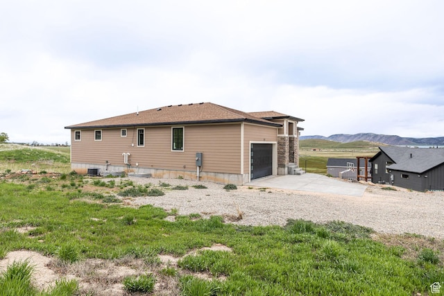 207 E Clubhouse Dr Unit 40, Garden City, UT 84028 - view of property exterior featuring a garage, a mountain view, concrete driveway, and central AC unit