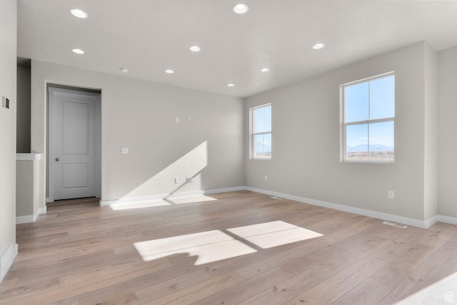 empty room with baseboards, recessed lighting, light wood-style floors, and visible vents