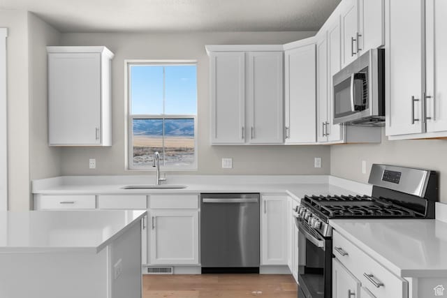 kitchen with visible vents, a sink, white cabinetry, and appliances with stainless steel finishes
