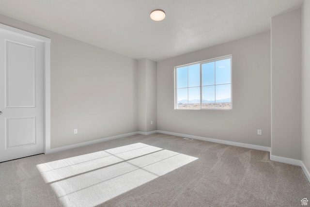 carpeted spare room with baseboards