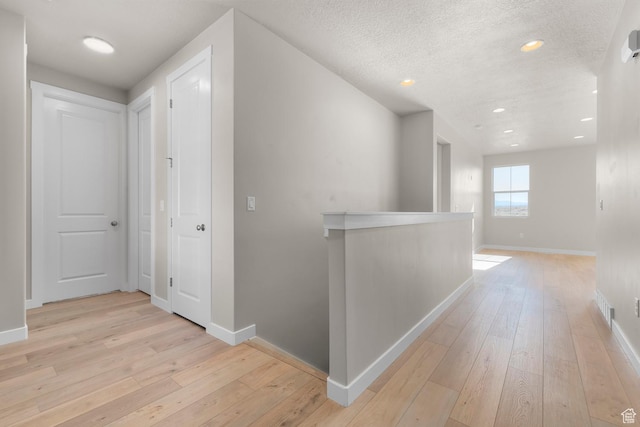 corridor featuring light wood-style floors and baseboards
