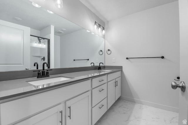 full bathroom featuring baseboards, a sink, marble finish floor, and double vanity