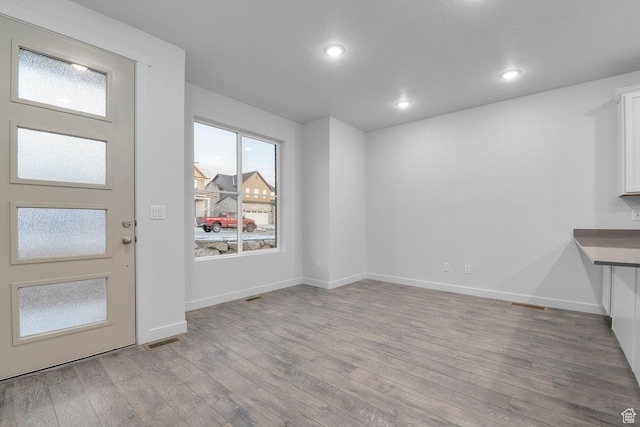 entryway featuring baseboards, recessed lighting, wood finished floors, and visible vents